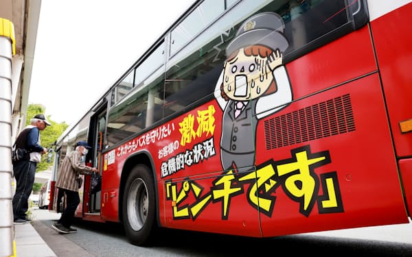 危機を訴えるラッピングをした北九州市営バス（5月28日、同市のJR戸畑駅前）
